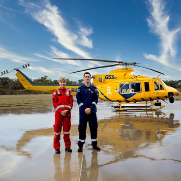 RAC Rescue crew stand in front of the helicopter on a concrete pad